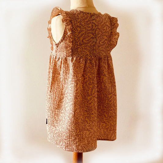 Achterzijde van het jurkje Zand blaadjes met ruffle details. Handgemaakte en duurzame kinderkleding in maat 74-128, verkrijgbaar bij Cuteez.