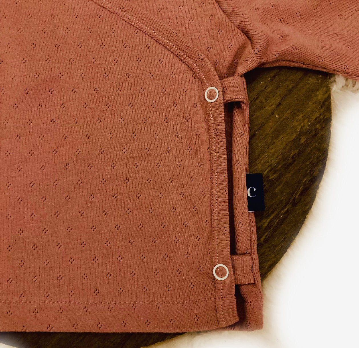 Detail van Baby overslag truitje roze ajour. Duurzame handgemaakte babykleding van webshop Cuteez