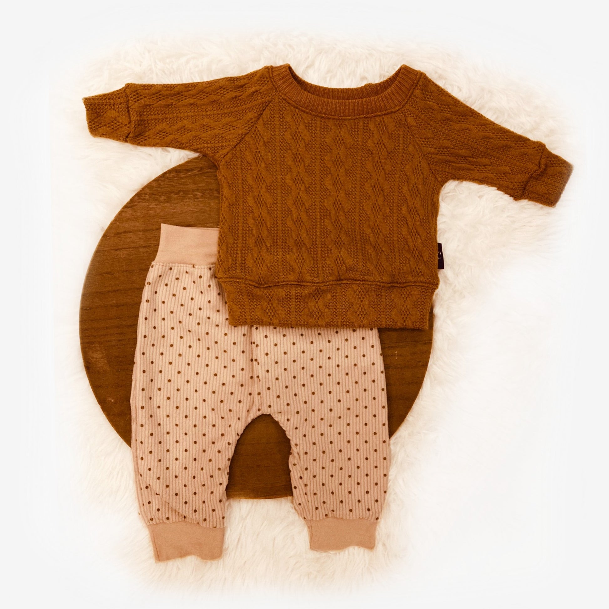 flatlay van babybroekje Stip handgemaakte babykleding duurzame webshop Cuteez met gebreid bruin truitje