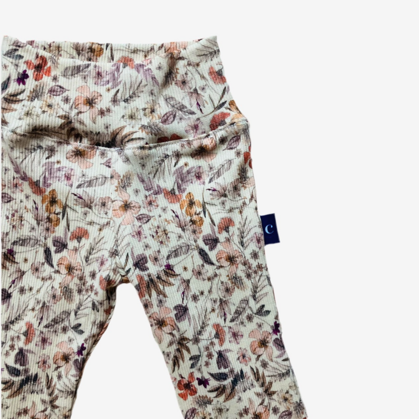 Close-up van Flare broek Flowers purple met elastische tailleband en kleurrijke bloemenprint. Handgemaakt in maat 50-128.