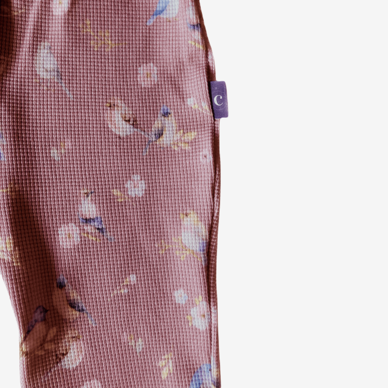Detail van: Duurzame kinderkleding voor meisjes bij Cuteez: flared broek van oudroze wafelstof met vogeltjesprint. Maat 74-152.