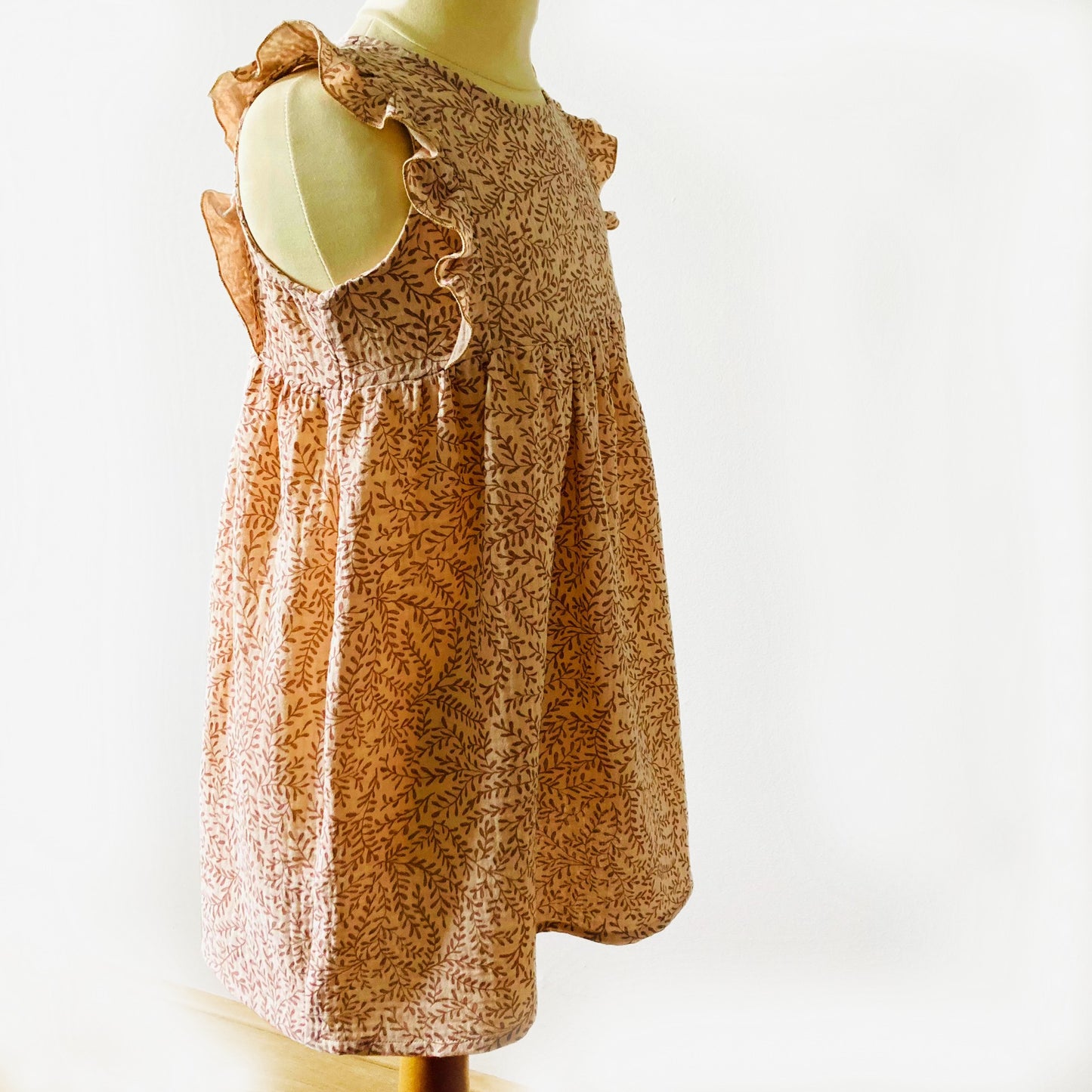 Zijaanzicht van jurkje Zand blaadjes met ruffle schouders. Duurzaam en handgemaakt, perfect voor meisjes in maat 74-128. Verkrijgbaar bij Cuteez.