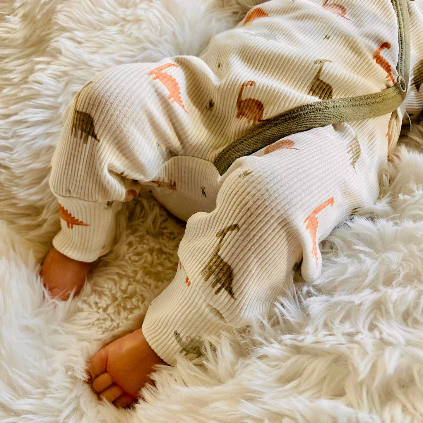 Detail onderkant van Schattig unisex boxpakje met Dino patroontje in zachte ribstof. Handgemaakte babykleding van webshop Cuteez.