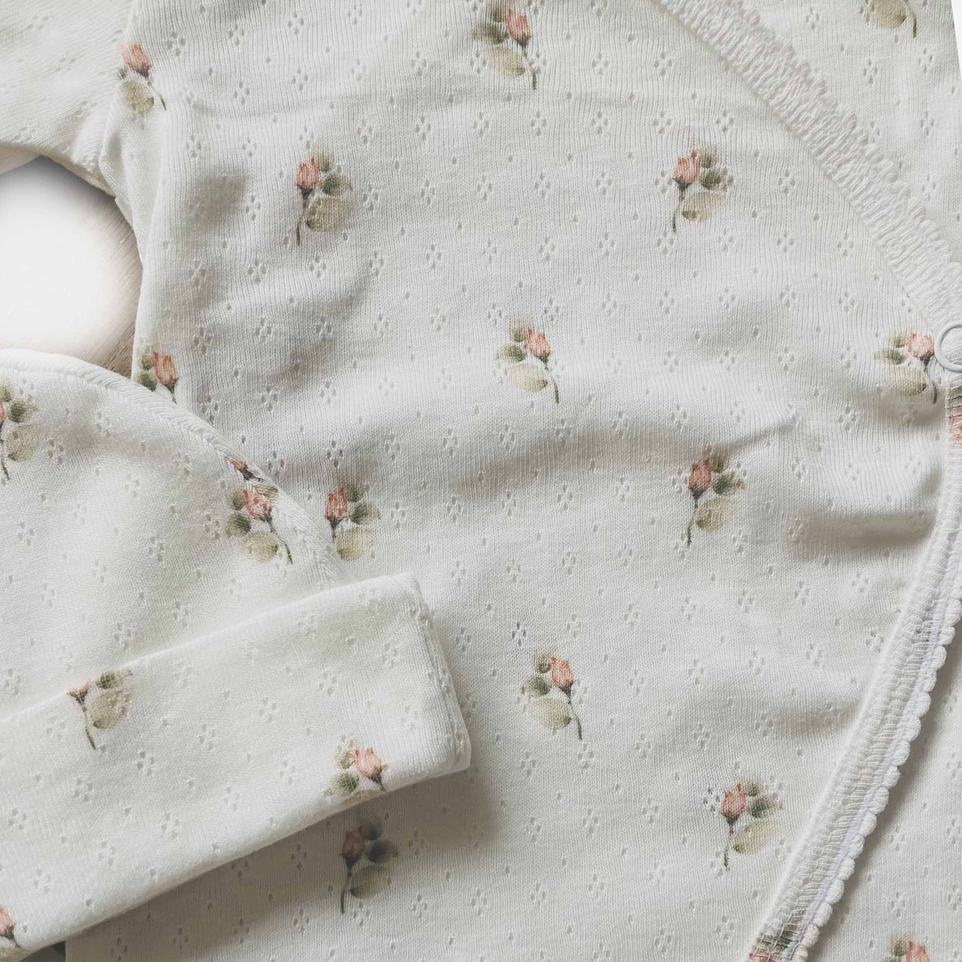 Handgemaakt ajour baby boxpakje met klein roosjespatroon en ruffles, gemaakt van zachte katoenen kwaliteitsstof.