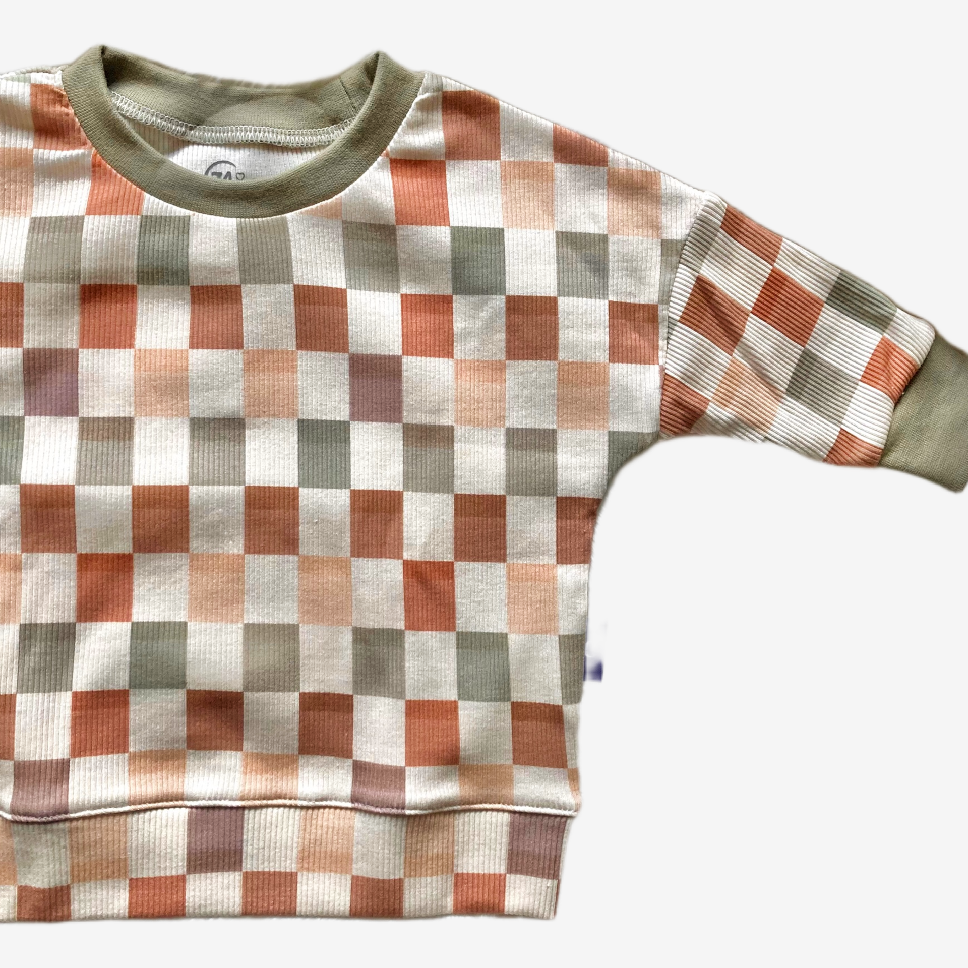 Detail van de ribstof en geblokte structuur van het handgemaakte truitje ‘Blocks